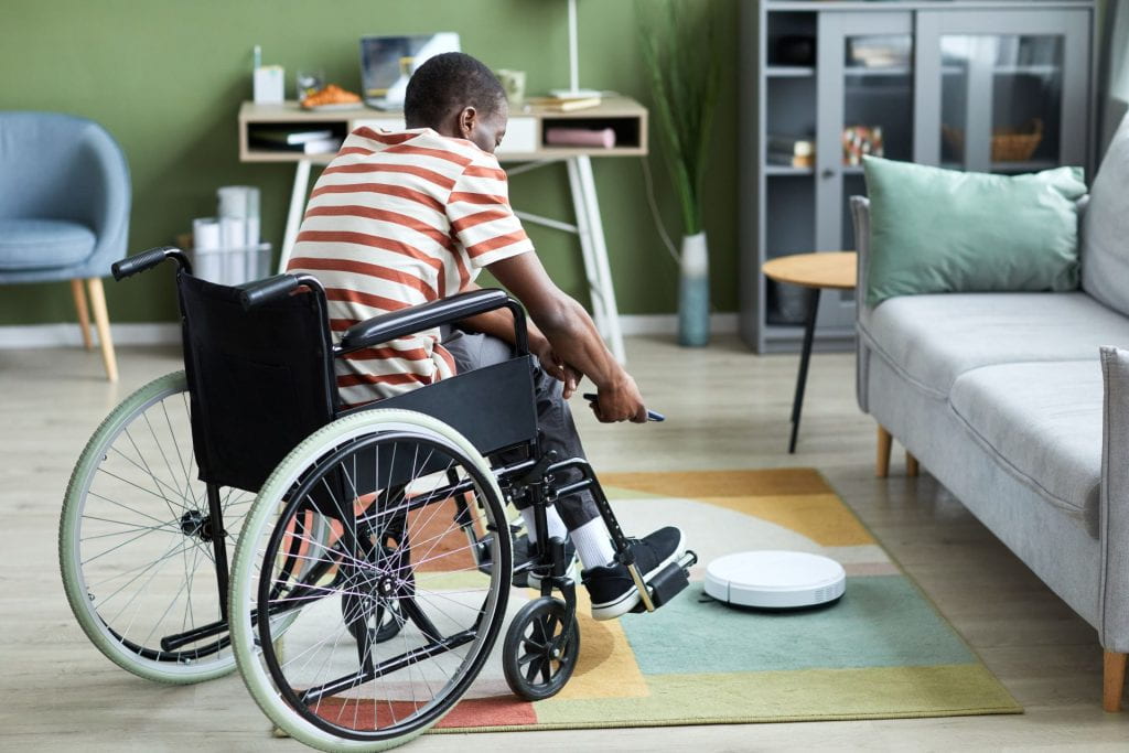 Person in wheelchair controlling vacuum robot